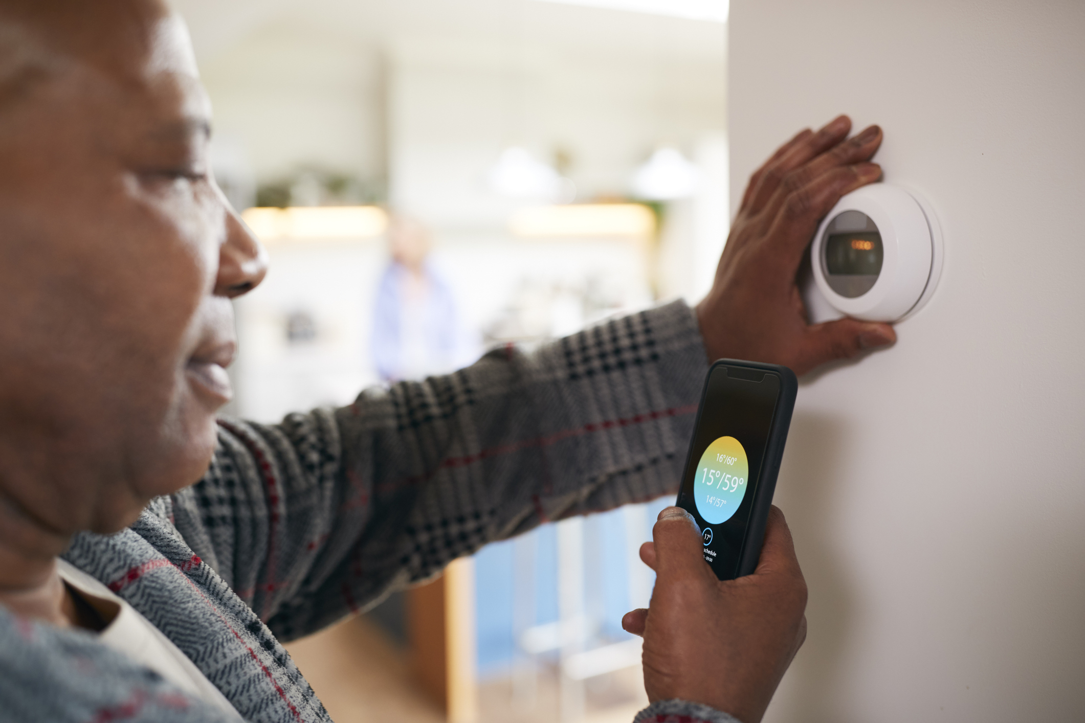 Woman uses app to set thermostat.